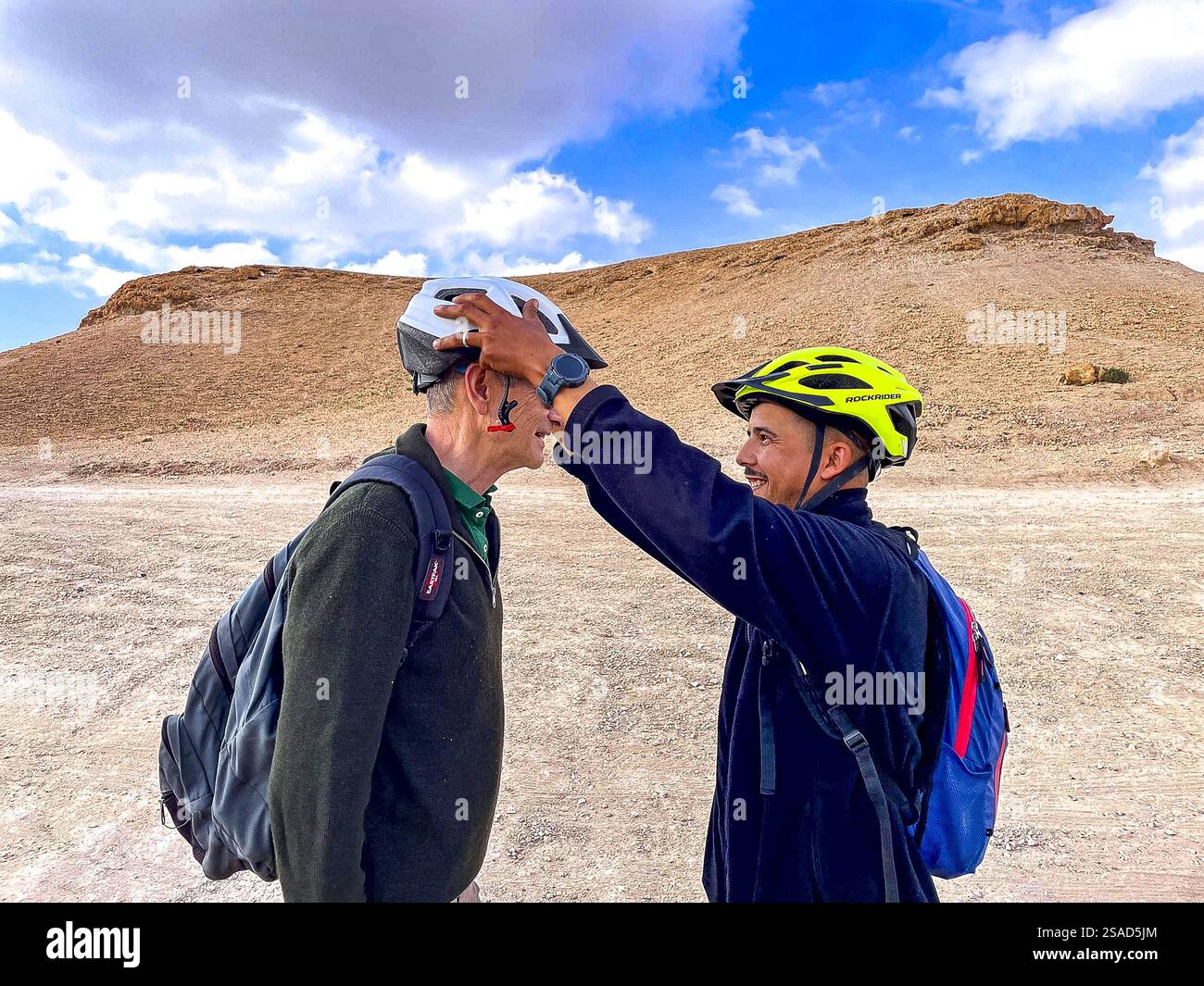 Tourist und Reiseleiter machen sich bereit für eine Mountainbike-Fahrt in der Wüste Agafay, Marokko Stockfoto Tourist und Reiseleiter machen sich bereit für eine Mountainbike-Fahrt in der Wüste Agafay, Marokko Stockfoto