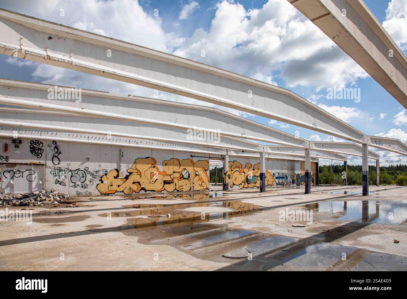 Sichtbetonbalken und Graffitis an der Wand eines verlassenen und halb abgerissenen Fabrikgebäudes in Paimio, Finnland Stockfoto