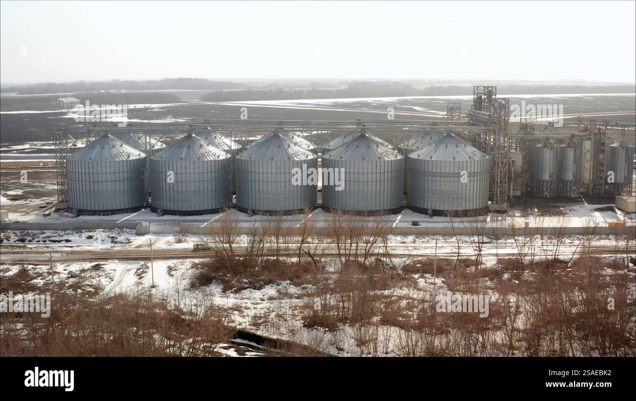 Metallkornsilos zur Lagerung von Erntegut in großen landwirtschaftlichen Verarbeitungsbetrieben im Winter Stockfoto