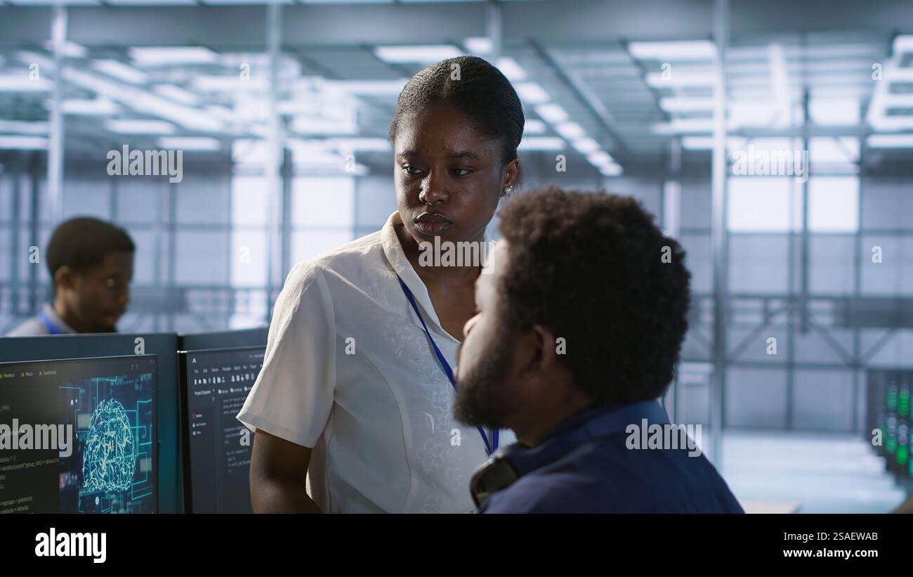 Manager, der Feedback vom Rechenzentrumsingenieur erhält, der die Netzwerkinfrastruktur des Unternehmens verwaltet. Teamleiter im Bereich Server Hub Listening Worker sorgt für optimale Systemleistung, Kamera A Stockfoto