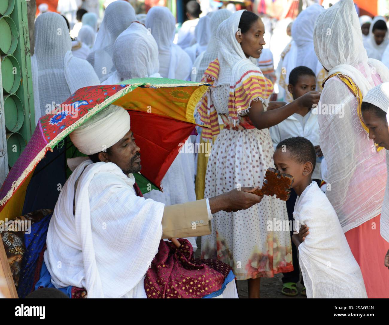Ein äthiopisch-orthodoxer Priester segnet während der Sonntagsgebete die Gläubigen in einer örtlichen Kirche. Foto in Gondar, Äthiopien. Stockfoto