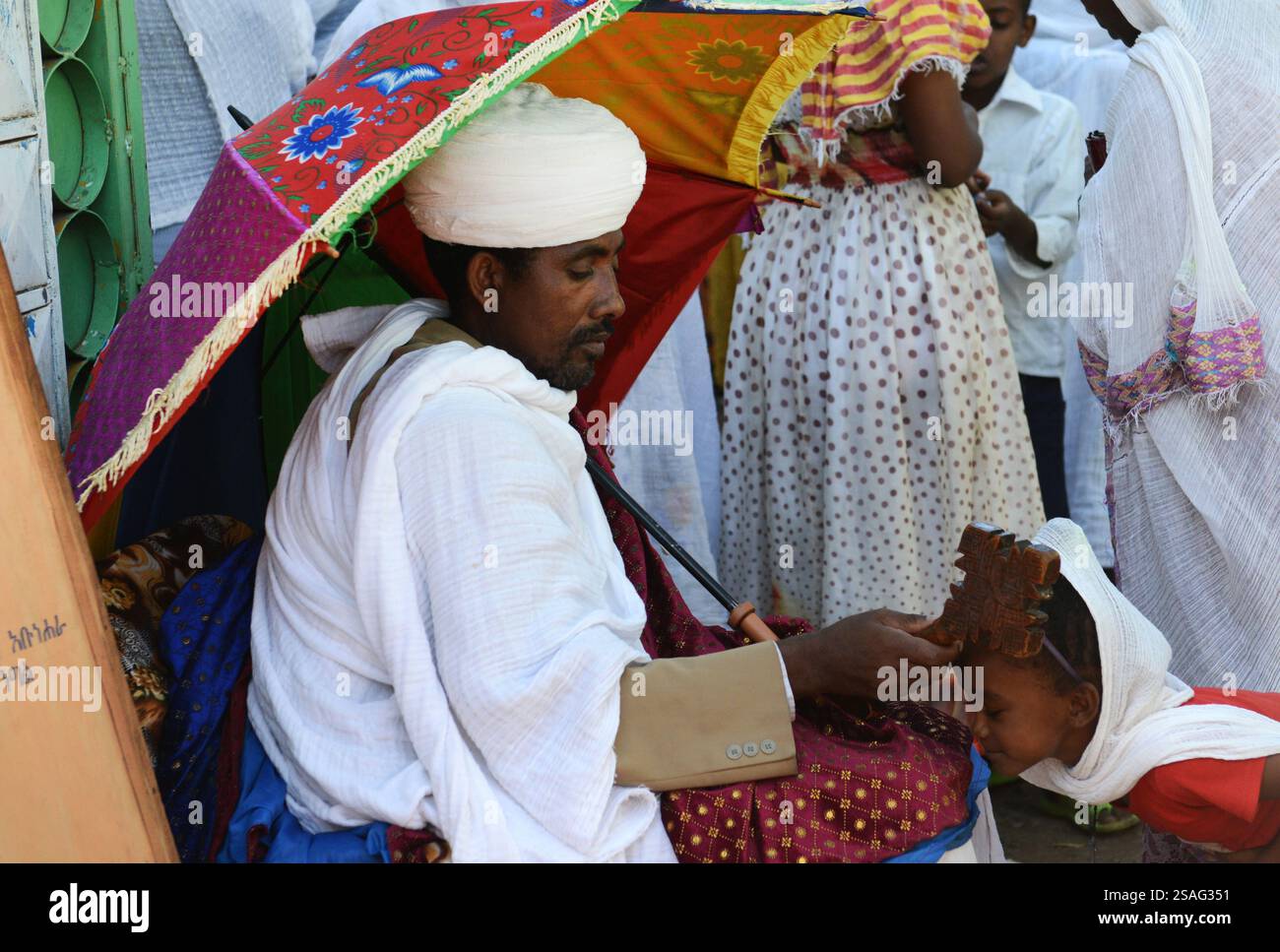 Ein äthiopisch-orthodoxer Priester segnet während der Sonntagsgebete die Gläubigen in einer örtlichen Kirche. Foto in Gondar, Äthiopien. Stockfoto