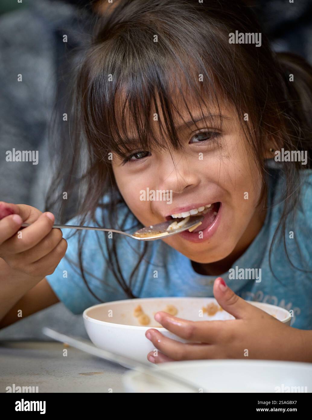 Aleka Mendoza, ein vierjähriges Mädchen aus Venezuela, isst eine Mahlzeit im Zentrum für Aufmerksamkeit für Migranten, einem von den Methodis betriebenen Unterschlupf in Apaxco, Mexiko Stockfoto