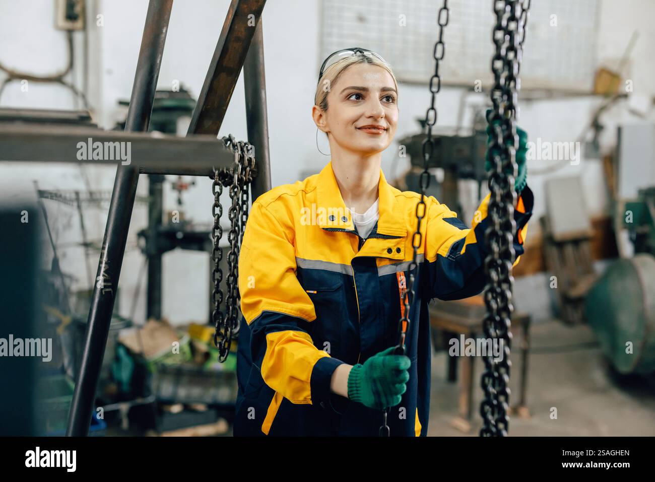 Frauen, die in der Schwermetallindustrie arbeiten, Fabrikhebe, die schwere Maschinenteile anheben Stockfoto