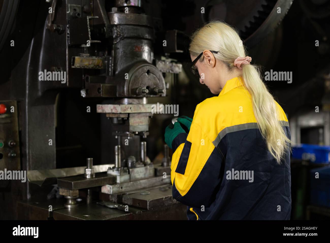 kaukasische Frauen arbeiten in der Schwermetallindustrie Fabrik Stanzstahl Maschine Stockfoto