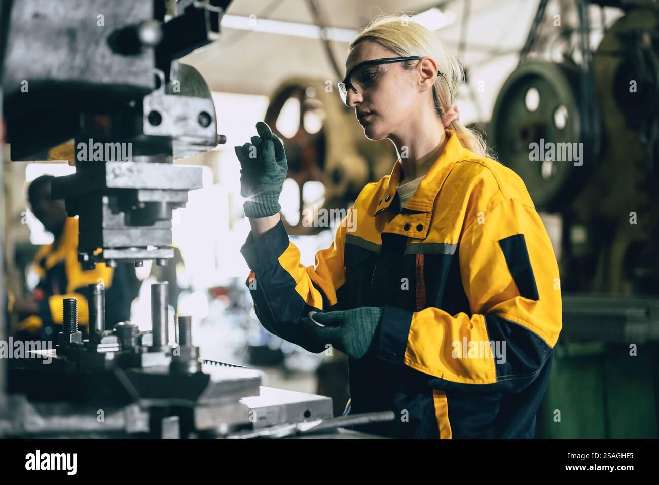 Kaukasische Frauen arbeiten in der Schwermetallindustrie Fabrik Stanzstahl Maschine Stockfoto