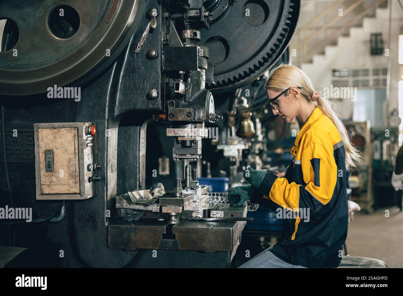 Kaukasische Frauen arbeiten in der Schwermetallindustrie Fabrik Stanzstahl Maschine Stockfoto
