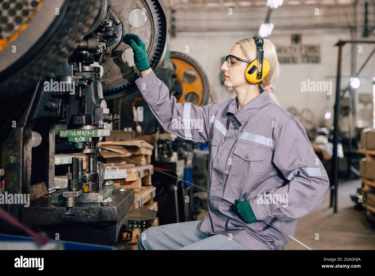 kaukasische Frauen arbeiten in der Schwermetallindustrie Fabrik Stanzstahl Maschine Stockfoto