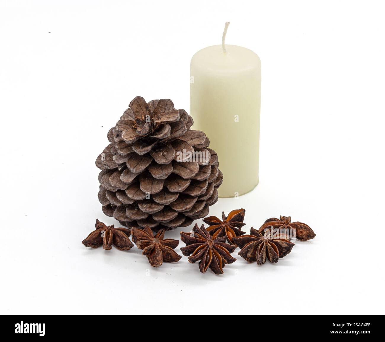 Natürlicher brauner Kiefernzapfen, duftender Badian (Sternanis) und helle Kerze auf einem sauberen weißen Hintergrund. Minimalistisches Stillleben. Für Weihnachtskarten. Stockfoto