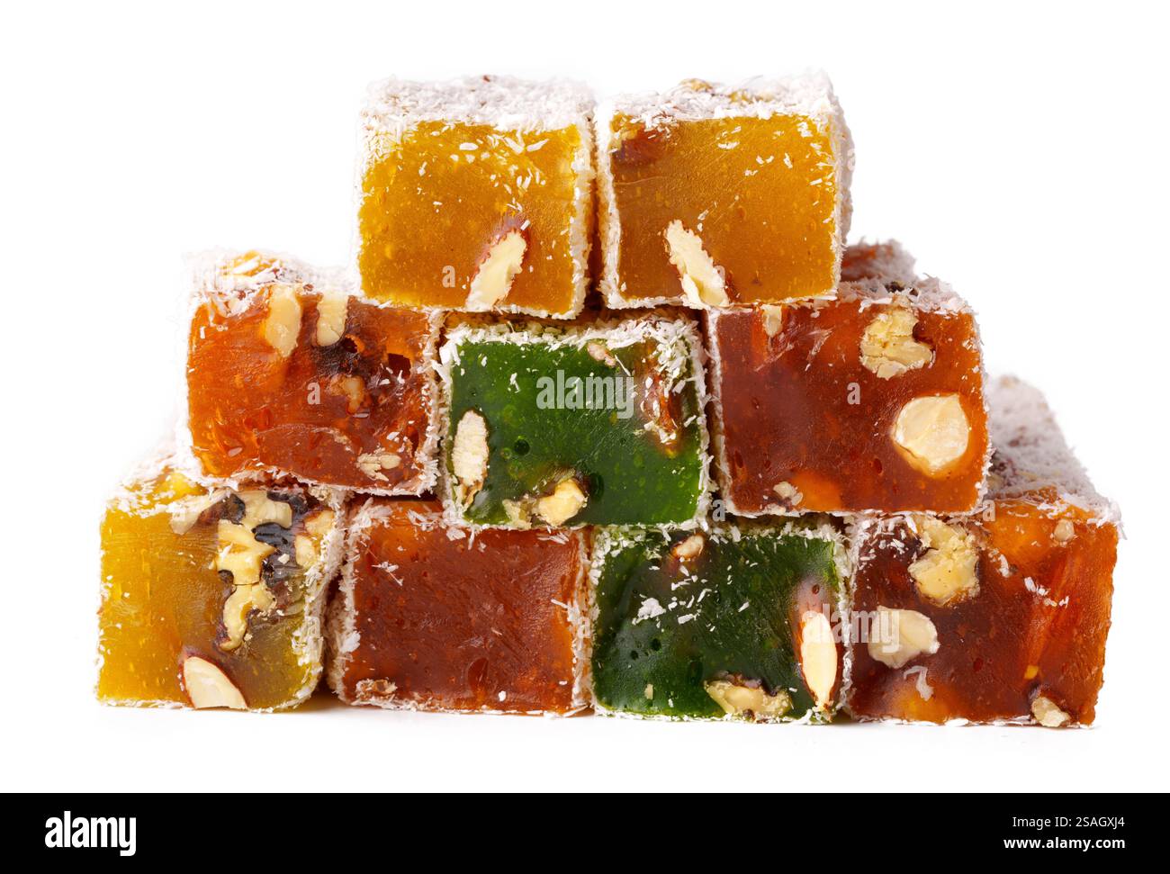 Farbenfrohe Auswahl an traditionellen türkischen Delikatesswürfeln, die zusammen mit Nüssen auf weißem Hintergrund gestapelt sind Stockfoto