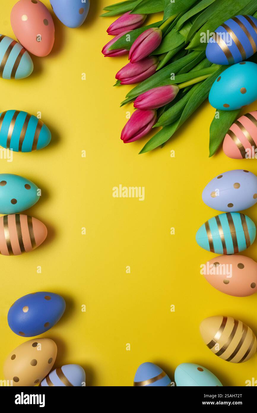 Osterfest-Konzept. Ostereier und pinkfarbene Tulpen, Platz für Text Stockfoto