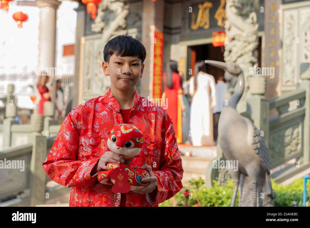 Vientiane, Laos. Januar 2025. Ein Junge posiert für Fotos mit einem schlangenförmigen Plüschtier vor einem Tempel in Vientiane, Laos, 29. Januar 2025. Quelle: Kaikeo Saiyasane/Xinhua/Alamy Live News Stockfoto