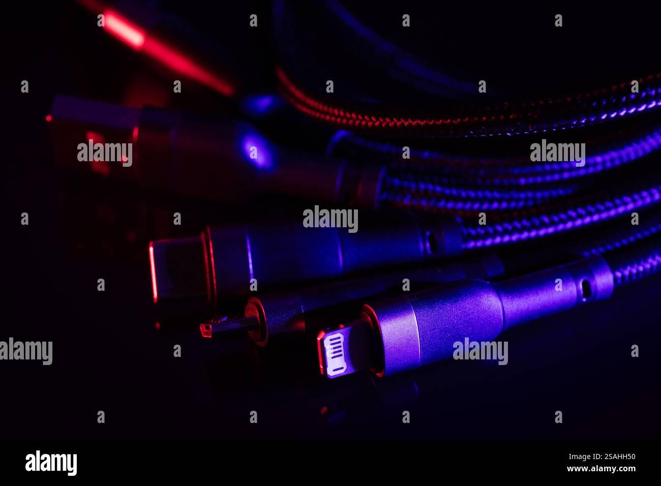 Verschiedene USB-Ladestecker isoliert auf dunklem Hintergrund. USB Typ C, Micro USB. Stockfoto