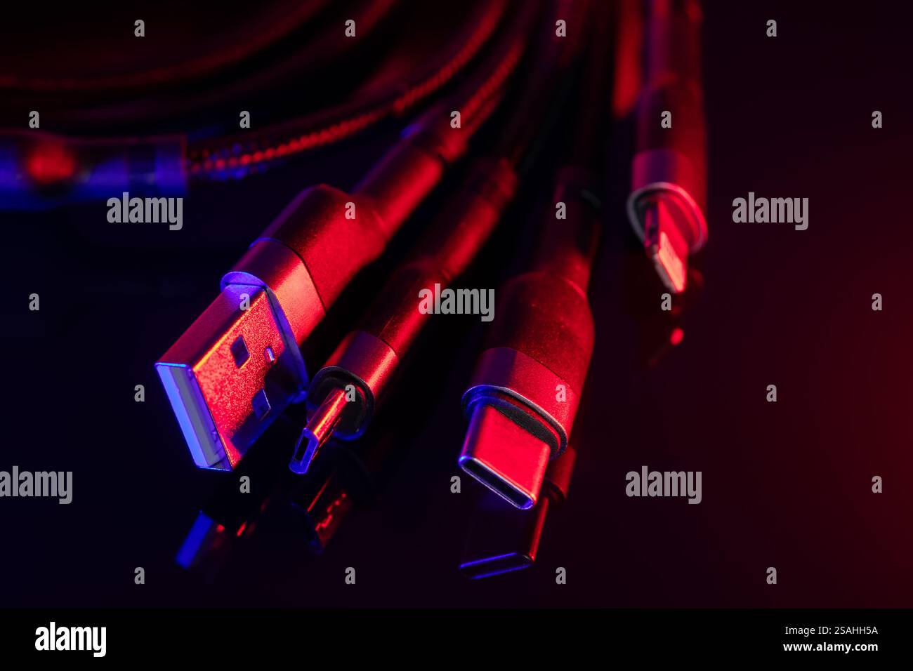 Verschiedene USB-Ladestecker isoliert auf dunklem Hintergrund. USB Typ C, Micro USB. Stockfoto