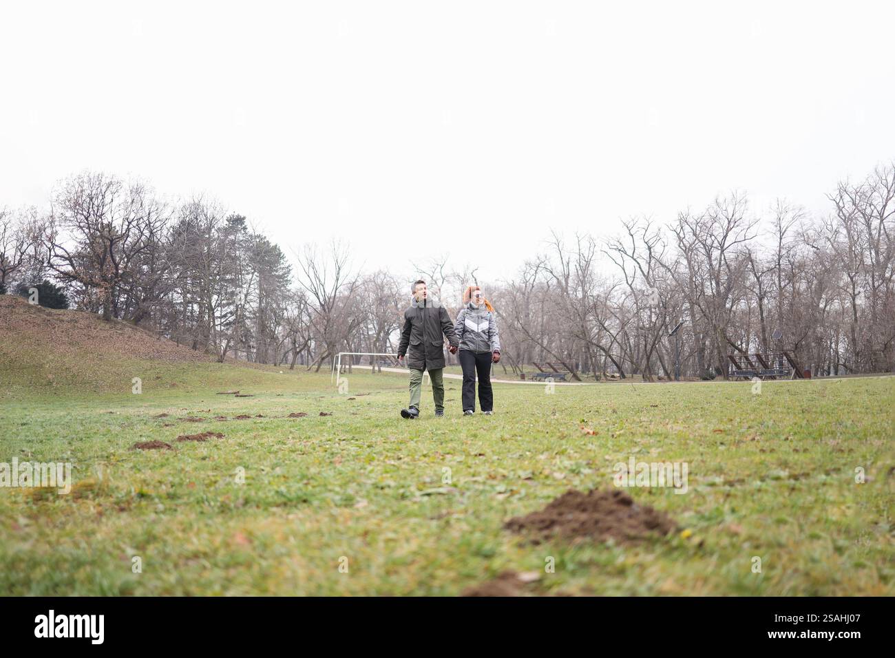 Heterosexuelles Paar, das zusammen läuft und sich im Park verbündet Stockfoto