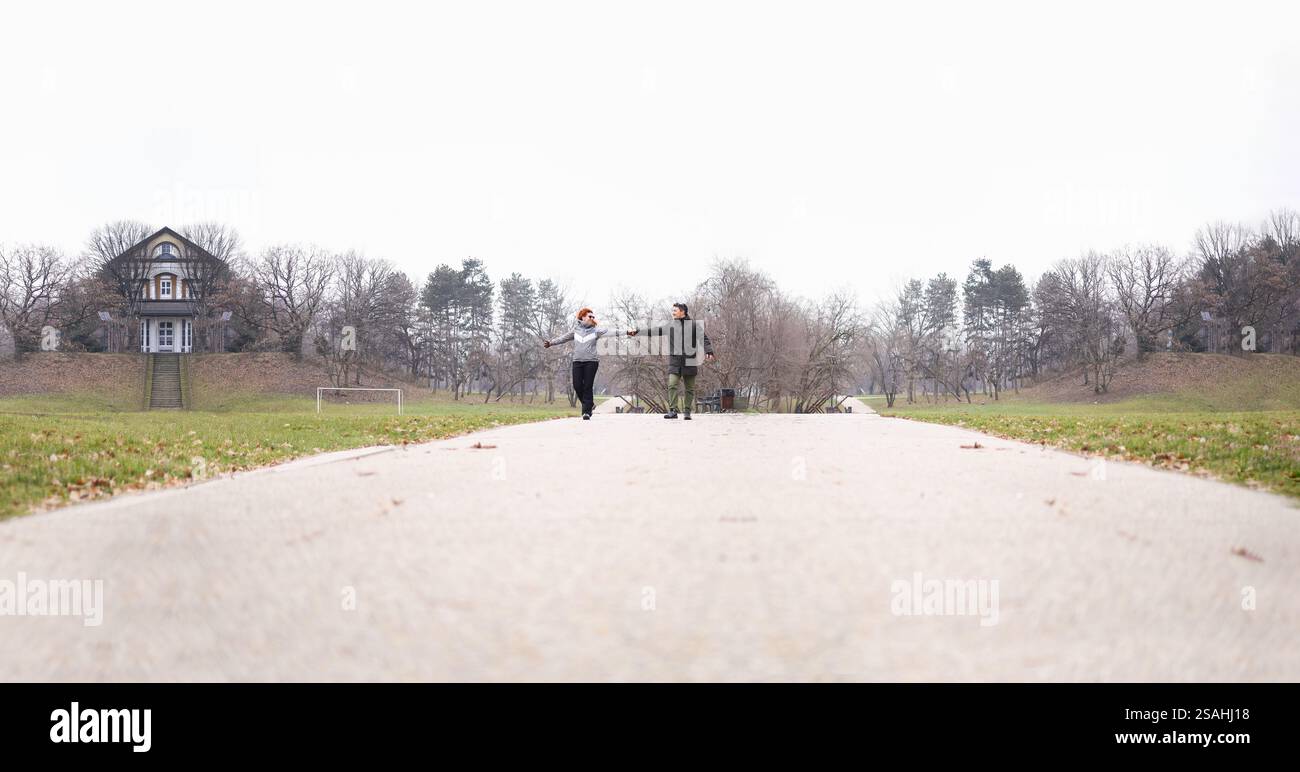 Romantisches Paar, das am Valentinstag die Hände auf einem Parkweg hält Stockfoto
