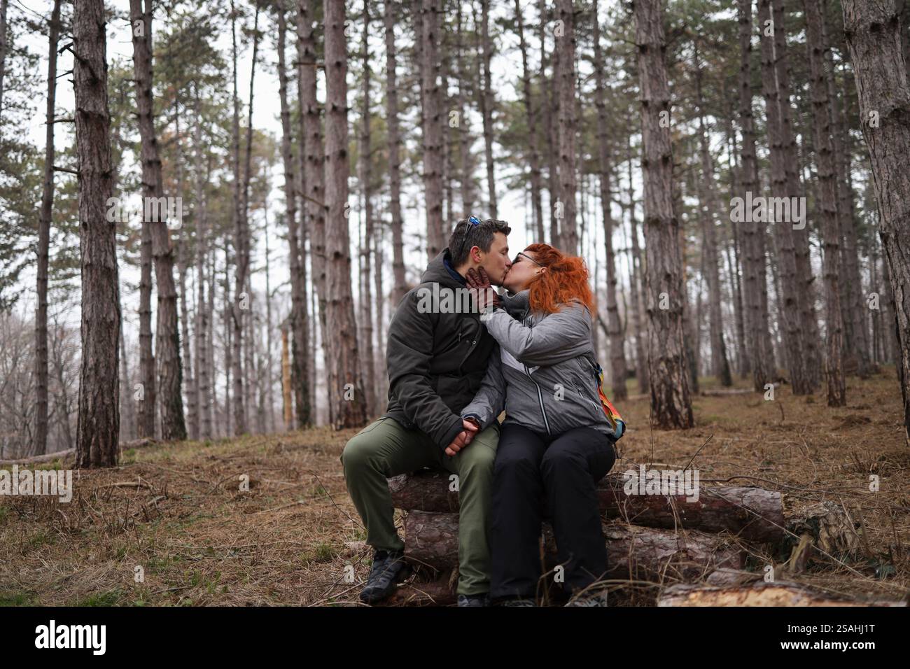 Emotionale Verbindung zwischen Mann und Frau im Wald. Einen Kuss am Valentinstag teilen. Stockfoto