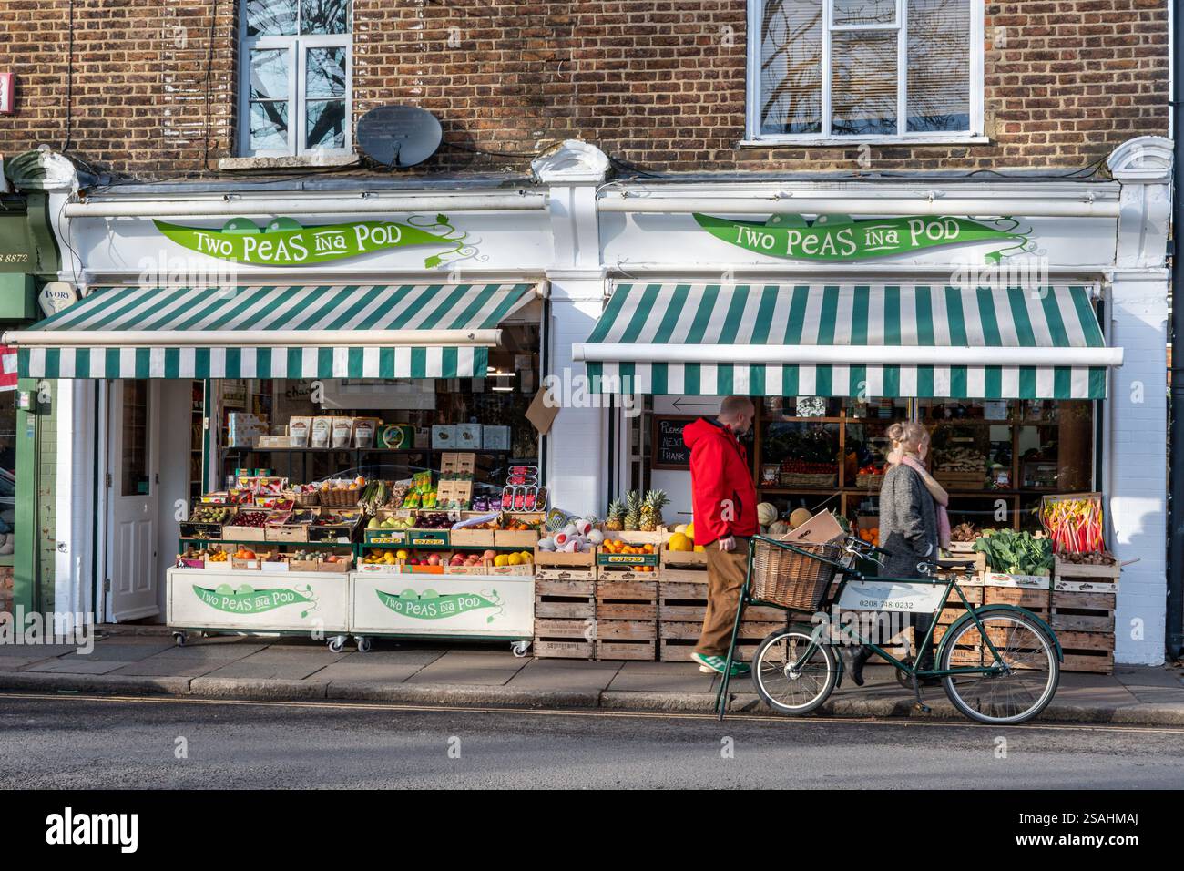 Ein Gemüsegeschäft namens Two Peas in a Pod in Barnes Village, London, England, Großbritannien, wo Leute einkaufen Stockfoto