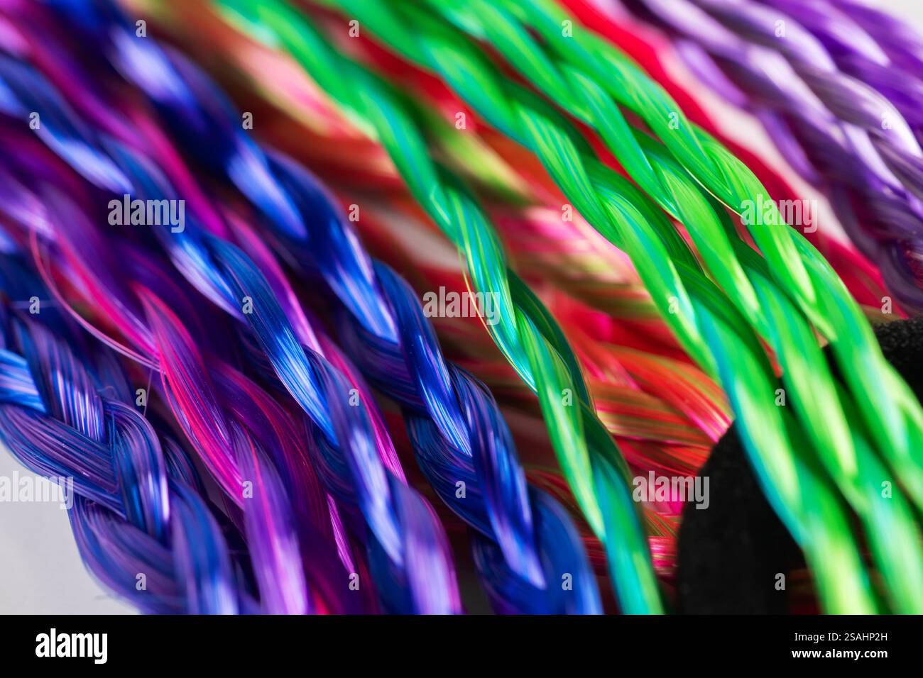 Farbige Zöpfe, Haarschmuck auf einem elastischen Band Hintergrund Nahaufnahme. Stockfoto