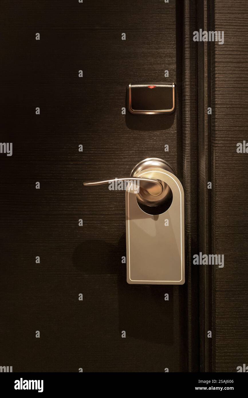 Leeres Etikett im „nicht stören“-Schild, das an der eleganten Hotelzimmertür hängt Stockfoto