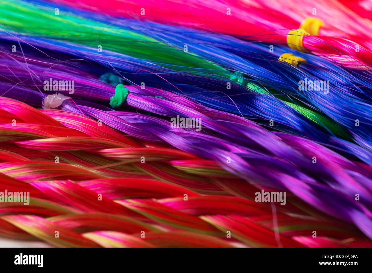 Farbige Zöpfe, Haarschmuck auf einem elastischen Band Hintergrund Nahaufnahme. Stockfoto