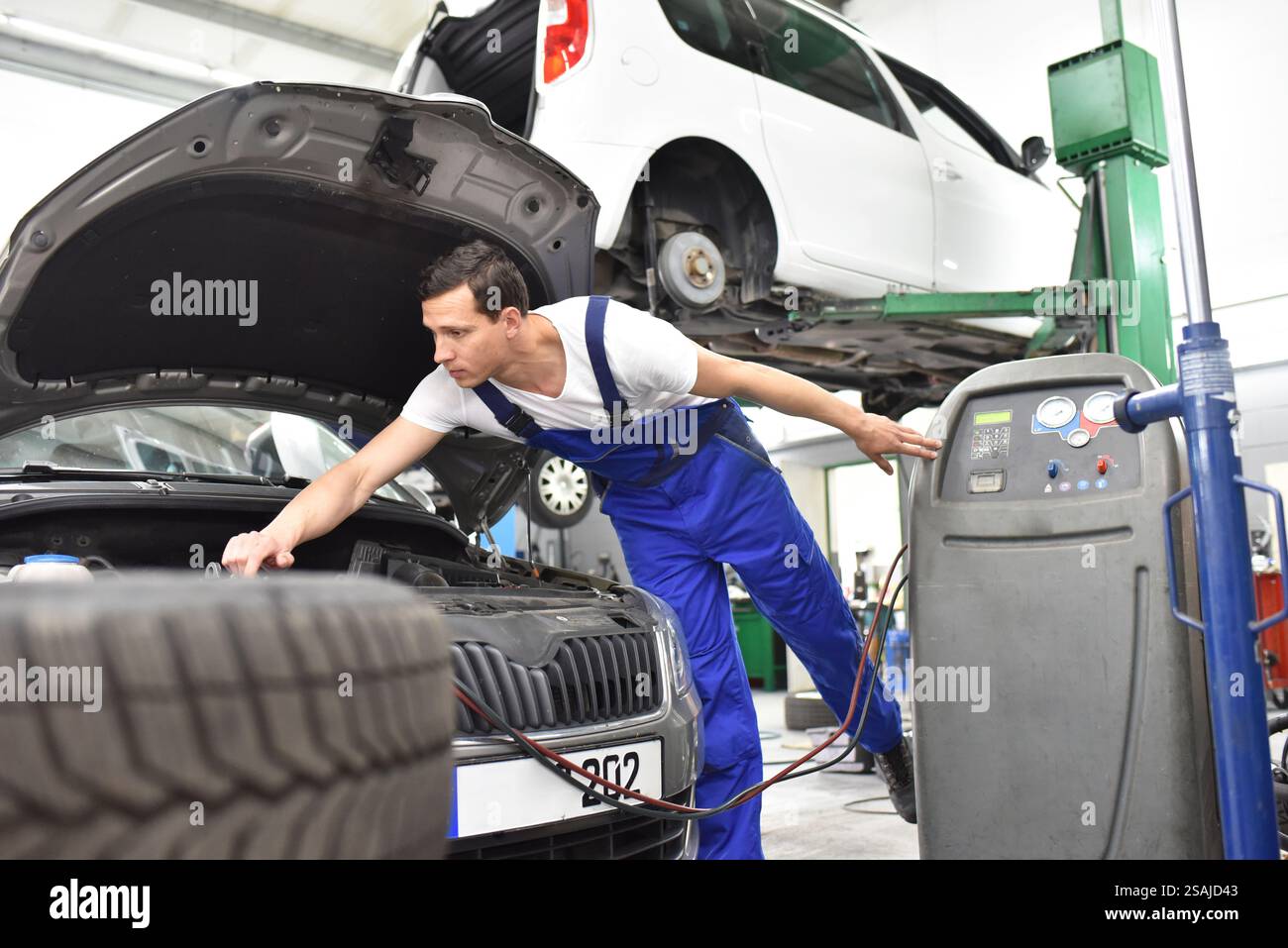 Automechaniker Reparaturen Bremsen von einem Fahrzeug auf der Hebebühne in einem Workshop Stockfoto