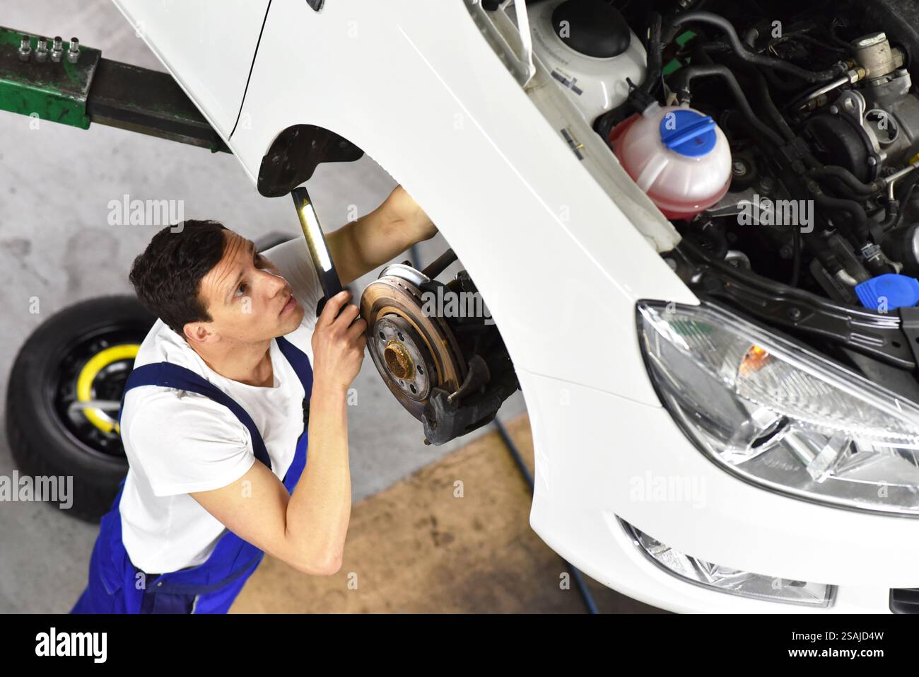 Automechaniker Reparaturen Bremsen von einem Fahrzeug auf der Hebebühne in einem Workshop Stockfoto