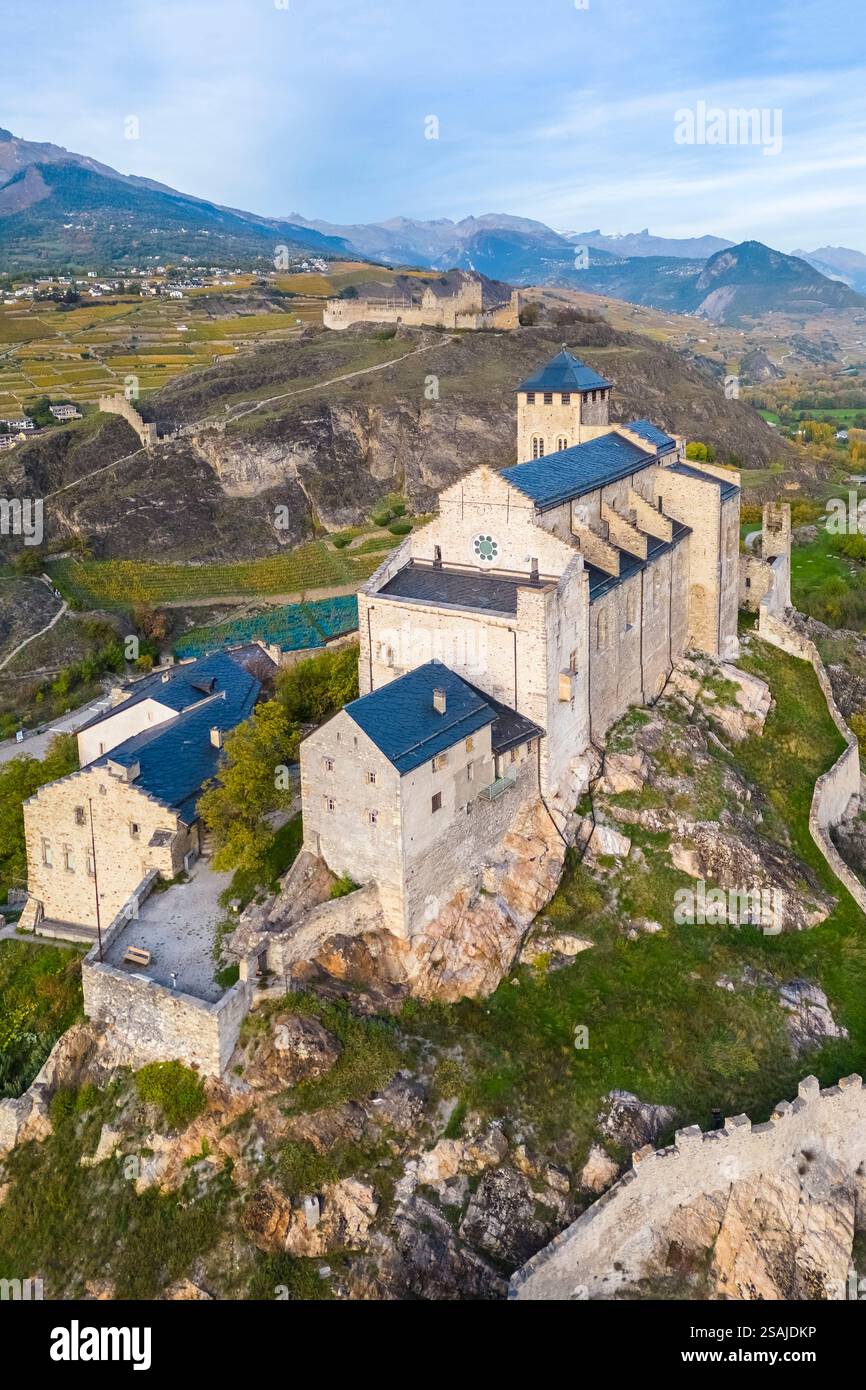 Aus der Vogelperspektive auf die Basilique de Valère in der Stadt Sion und die umliegenden Weinberge im Herbst. Kanton Wallis, Tal der Rhône, Schweiz. Stockfoto