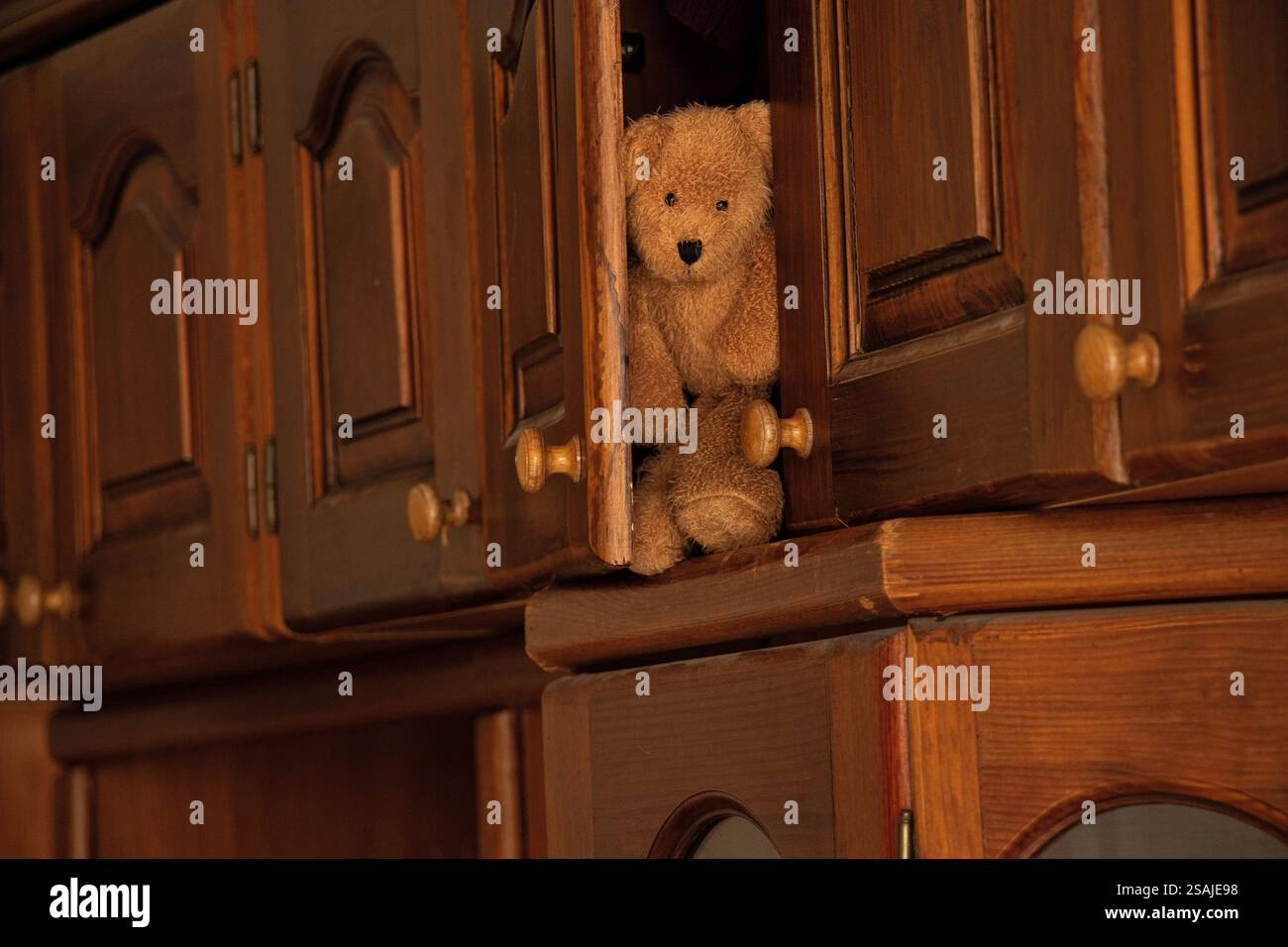 Alte Holzgarderobe im Schlafzimmer des Hauses und auf dem Regal steht ein Kinderteddybär, Möbel Stockfoto