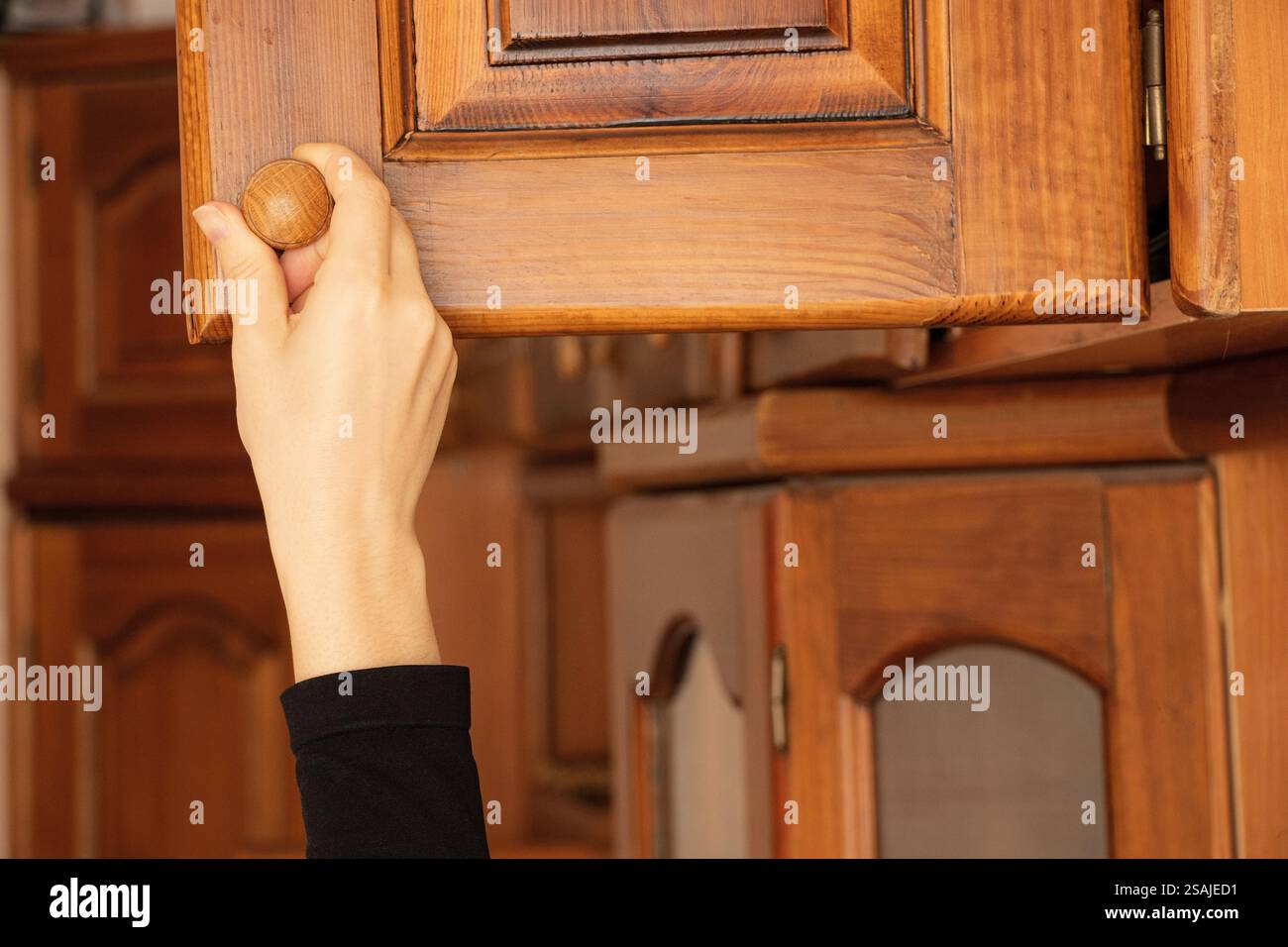 Frau Hand öffnet alten Holzschrank im Schlafzimmer zu Hause, alte Möbel Stockfoto