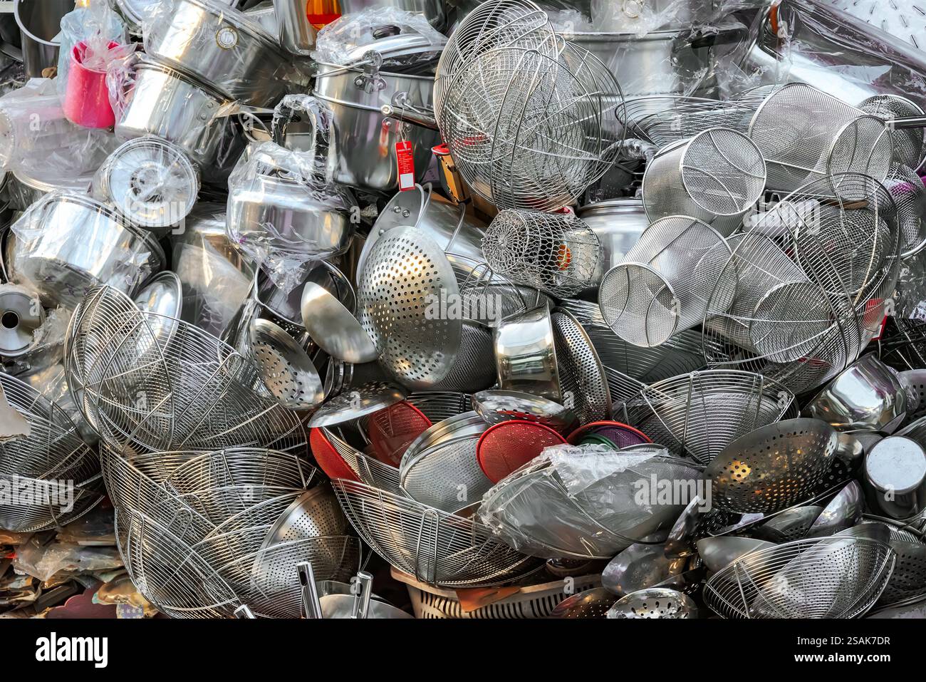 Ein riesiger Stapel von Küchenutensilien, Töpfen, Pfannen und Zubehör, die nach dem Zufallsprinzip aufeinander gestapelt werden, damit Kunden auswählen können. Stockfoto
