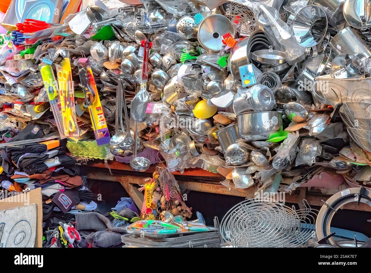 Ein riesiger Stapel von Küchenutensilien, Töpfen, Pfannen und Zubehör, die nach dem Zufallsprinzip aufeinander gestapelt werden, damit Kunden auswählen können. Stockfoto