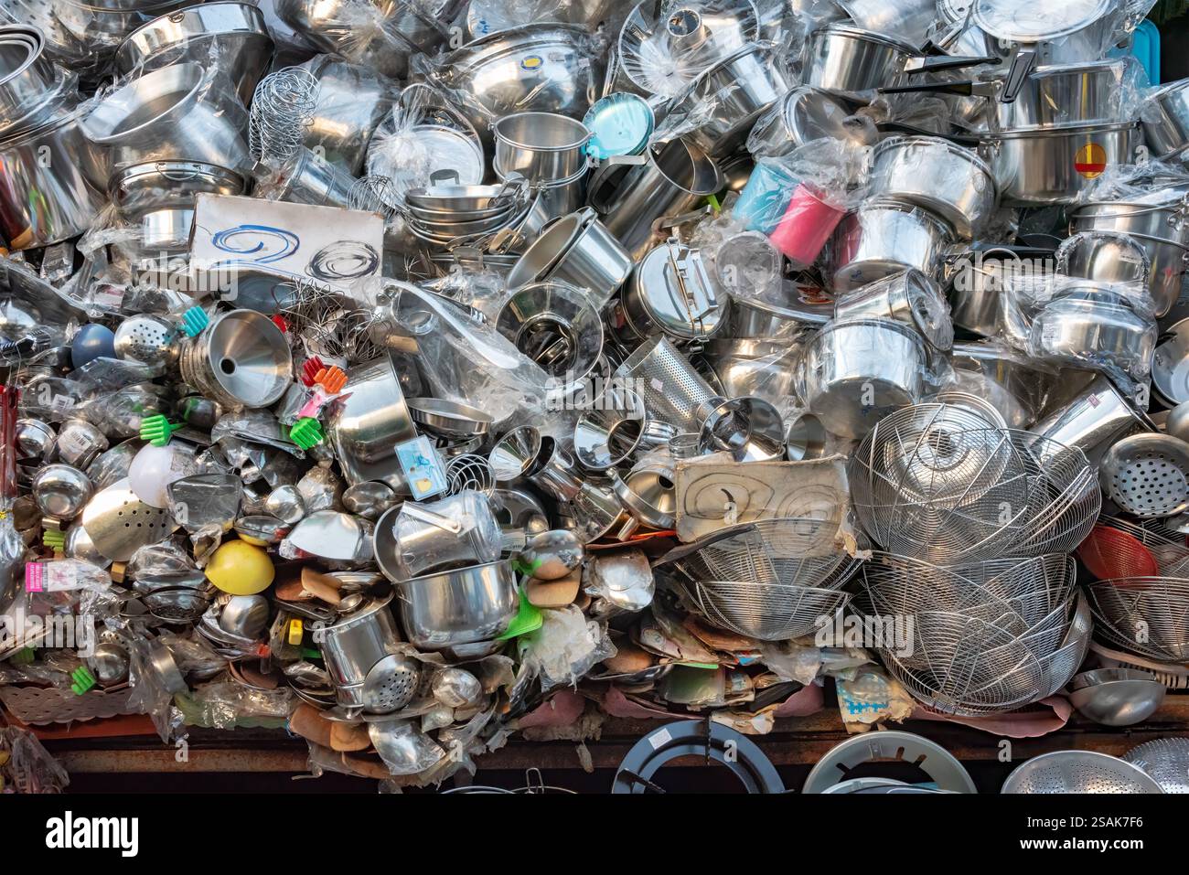 Ein riesiger Stapel von Küchenutensilien, Töpfen, Pfannen und Zubehör, die nach dem Zufallsprinzip aufeinander gestapelt werden, damit Kunden auswählen können. Stockfoto
