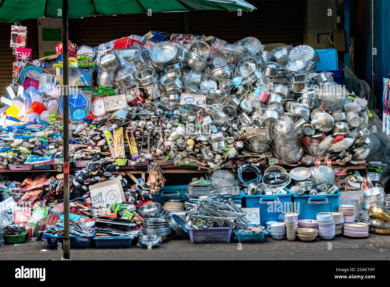 Ein riesiger Stapel von Küchenutensilien, Töpfen, Pfannen und Zubehör, die nach dem Zufallsprinzip aufeinander gestapelt werden, damit Kunden auswählen können. Stockfoto