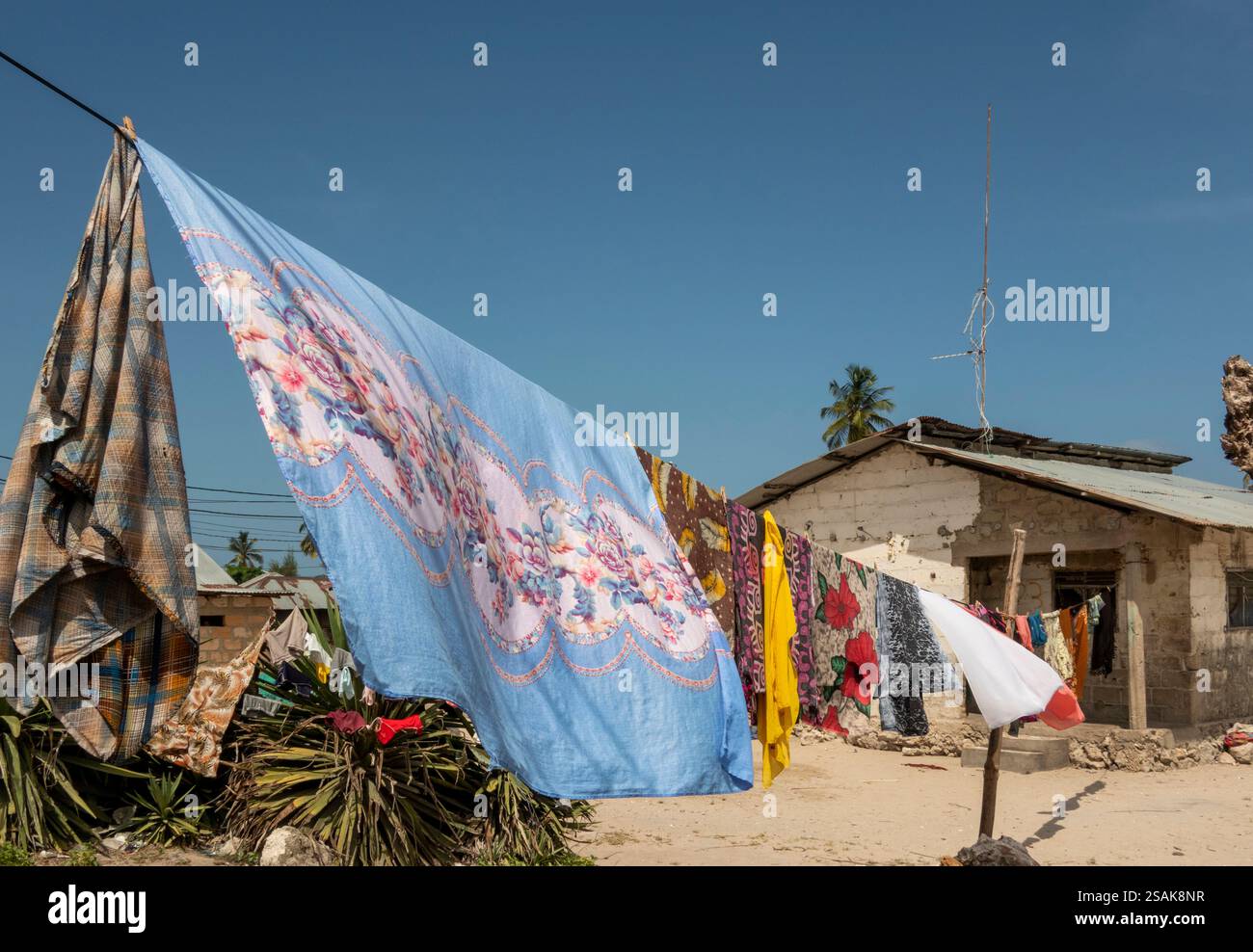 Afrika Tansania, Sansibar, Ostküste, Matemwe, bunte gewaschene Wäsche hängt vor dem Dorfhaus Stockfoto