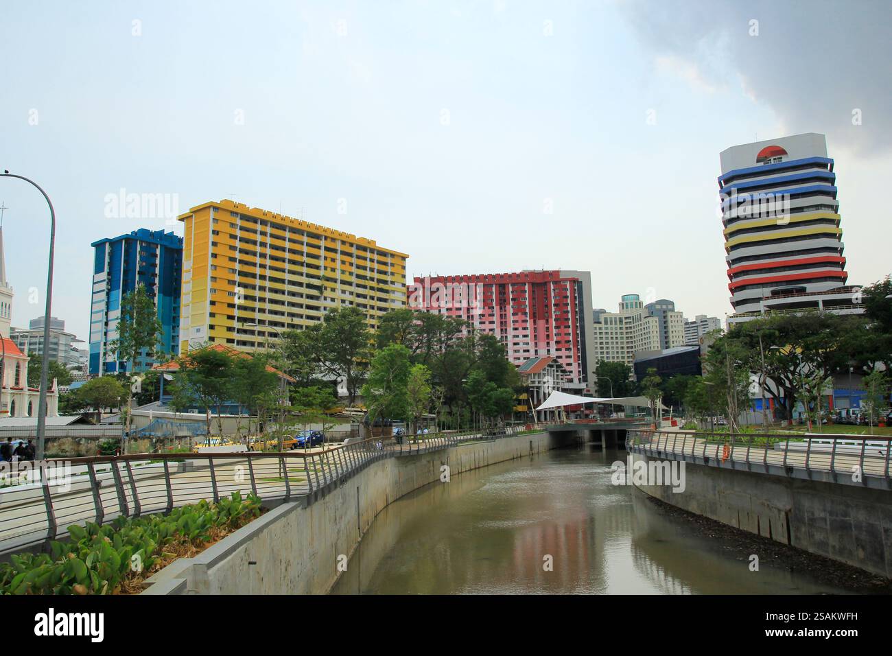 Ein sauberer Fluss trennt Stadtparks, Apartmentgebäude und Bürogebäude ordentlich angeordnet. Stockfoto