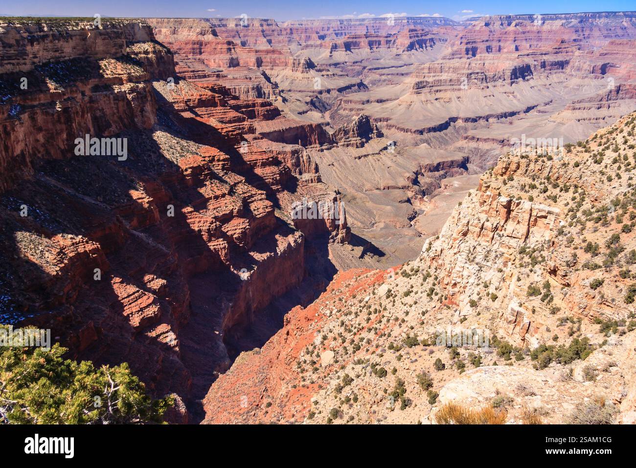 Der Grand Canyon ist ein wunderschöner und beeindruckender Anblick. Der Canyon ist mit roten Felsen gefüllt und von einer üppigen grünen Landschaft umgeben. Die Sonne ist s Stockfoto