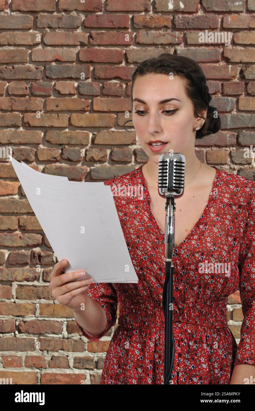 Frau in ein Vintage Mikrofon durchführen ein Hörspiel sprechen Stockfoto