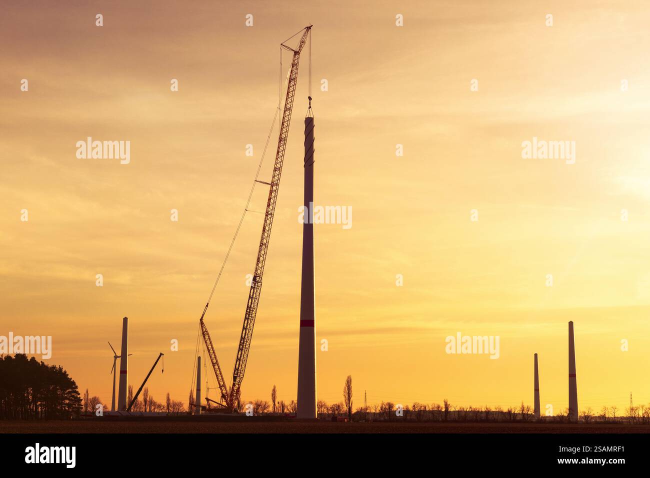 Silhouette eines großen Krans, der eine Windenergieanlage installiert Stockfoto