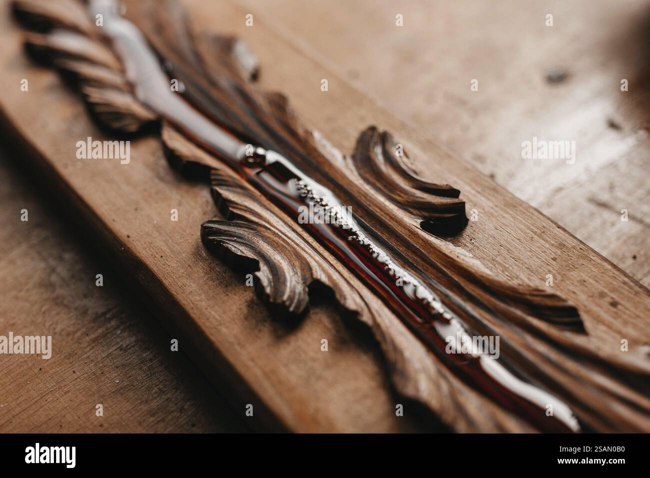 Nahaufnahme von Lack auf geschnitztem Holz, der seine komplizierten Muster unterstreicht Stockfoto