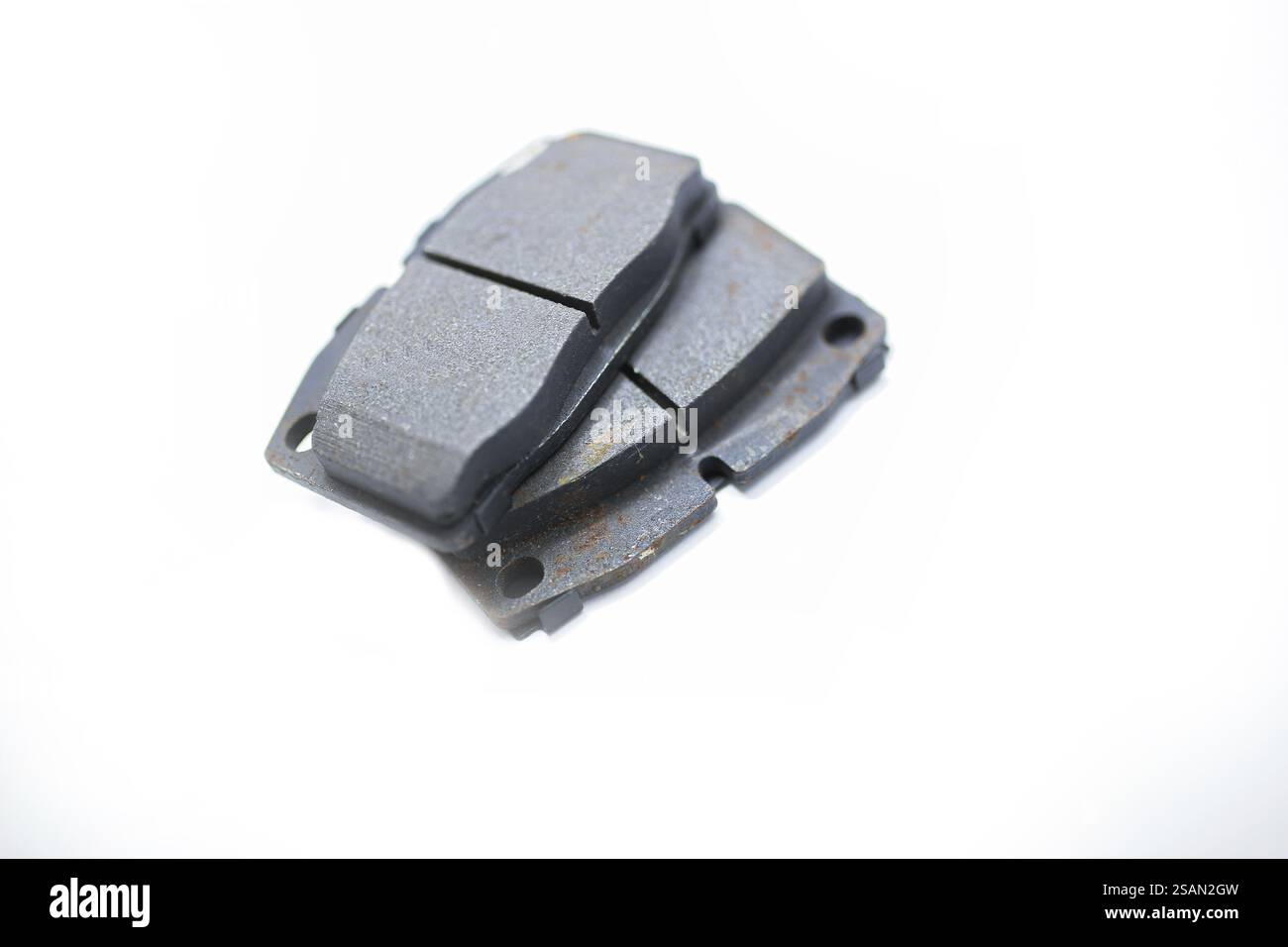 Nahaufnahme von Kfz-Bremsbelägen mit starkem Verschleiß, sichtbar auf weißem Hintergrund Stockfoto