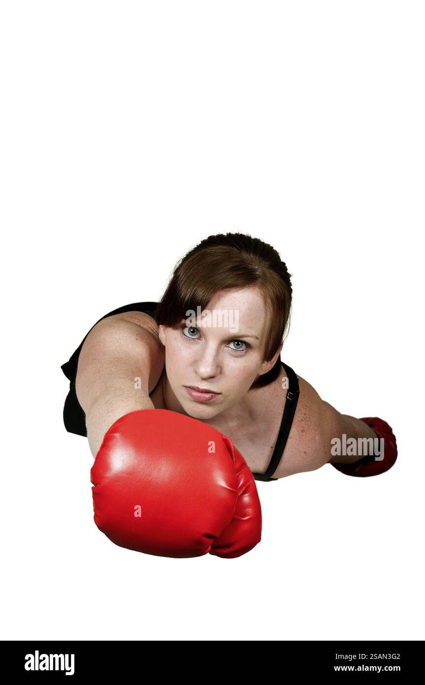 Die wunderschöne Superheldin fliegt mit Boxhandschuhen durch den Himmel Stockfoto