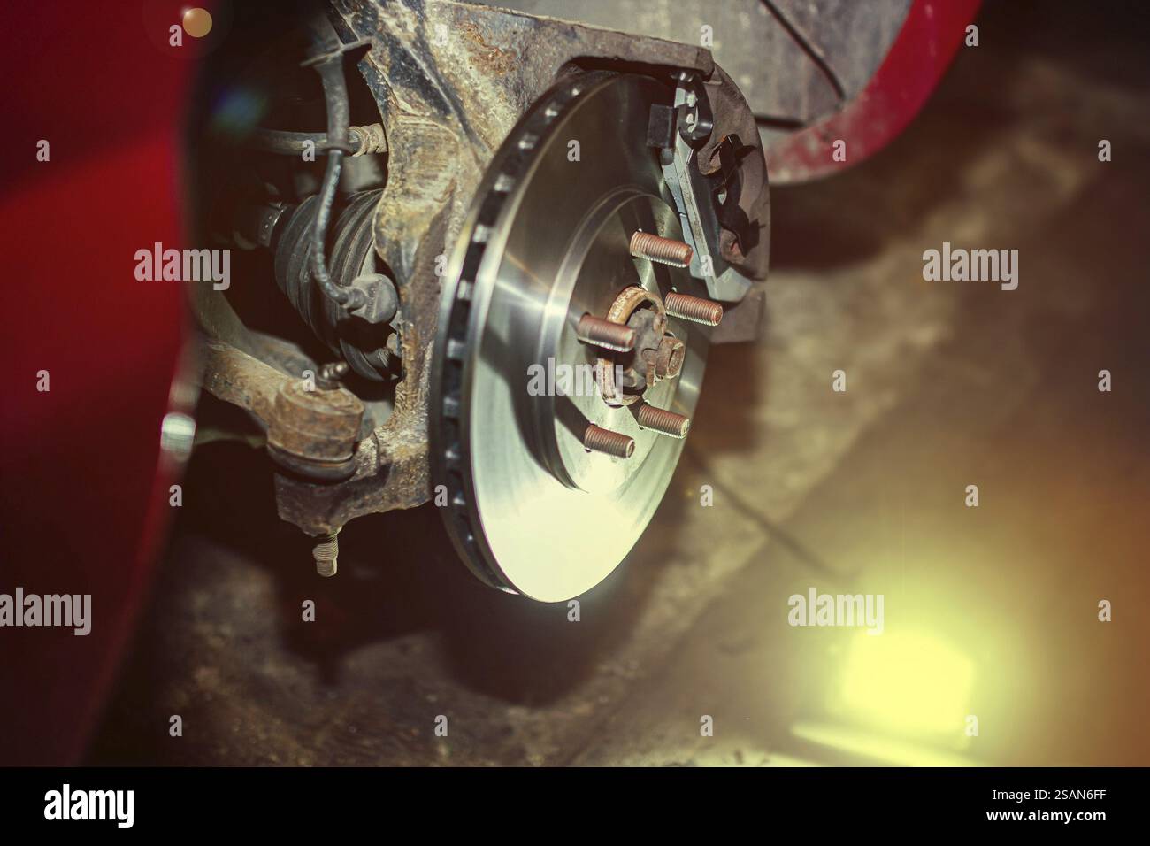 Ein Bremsrotor und eine Radaufhängung, die durch ein sanftes Licht beleuchtet werden Stockfoto