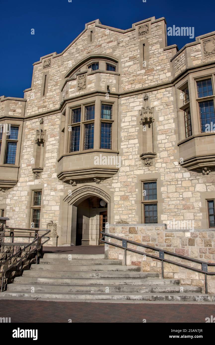 Ein großes Gebäude mit einer Steinfassade. Der Vordereingang hat eine Treppe, die hinauf führt. Das Gebäude hat viele Fenster, einschließlich eines großen Stockfoto