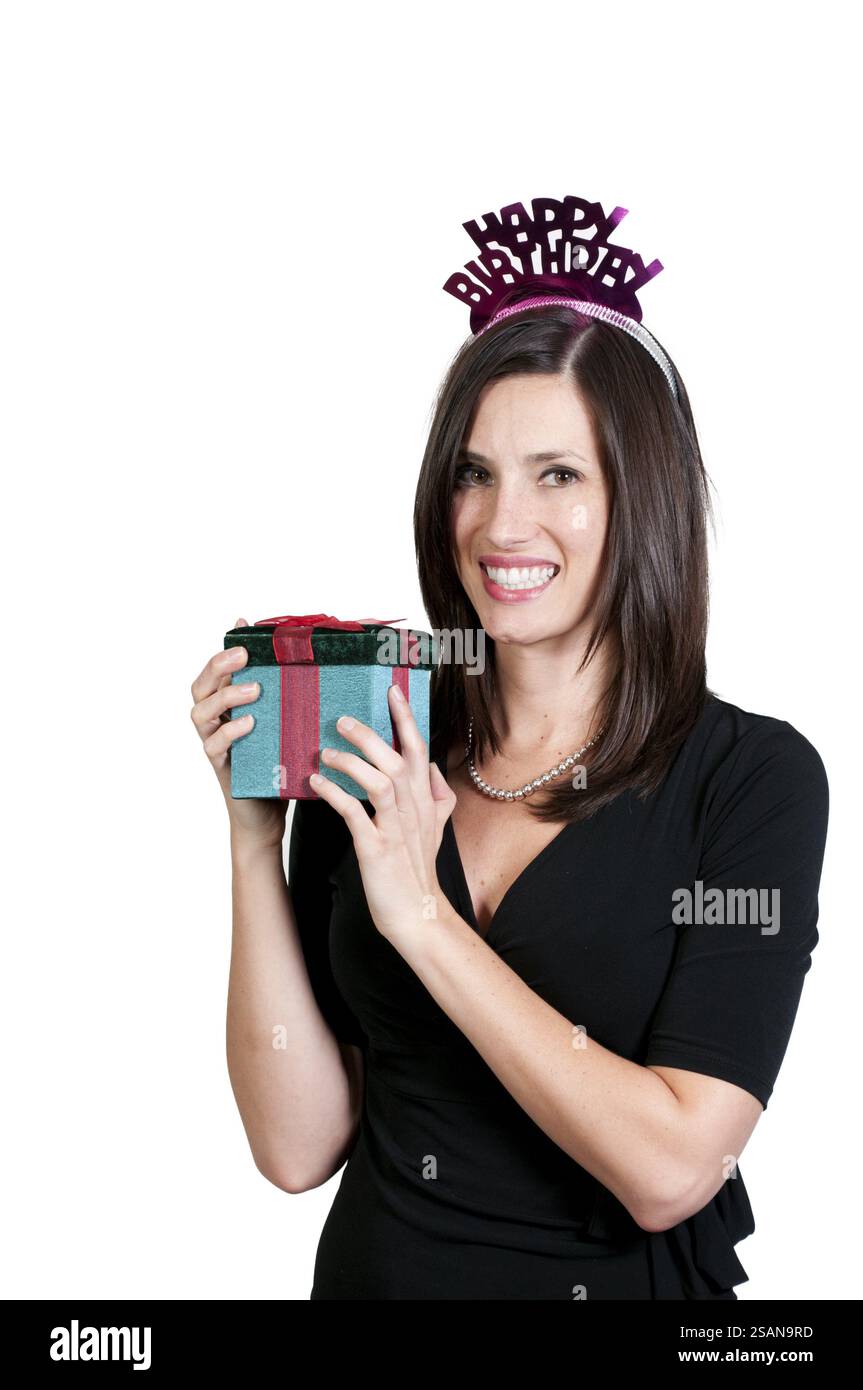 Eine schöne junge Frau, die ein Geburtstagsgeschenk öffnet Stockfoto