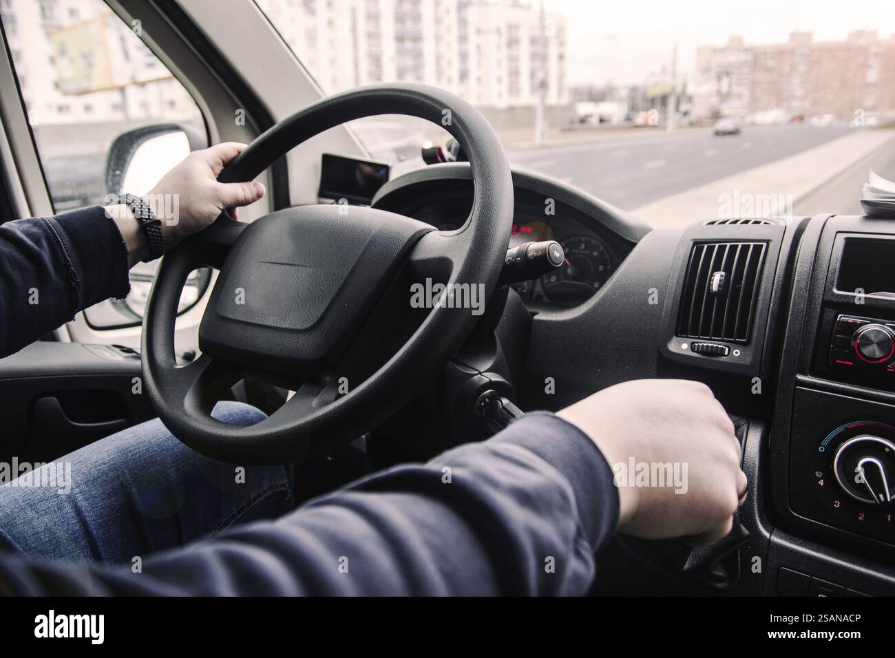 Fahrer, der ein Fahrzeug in einer städtischen Umgebung lässig handhabt Stockfoto