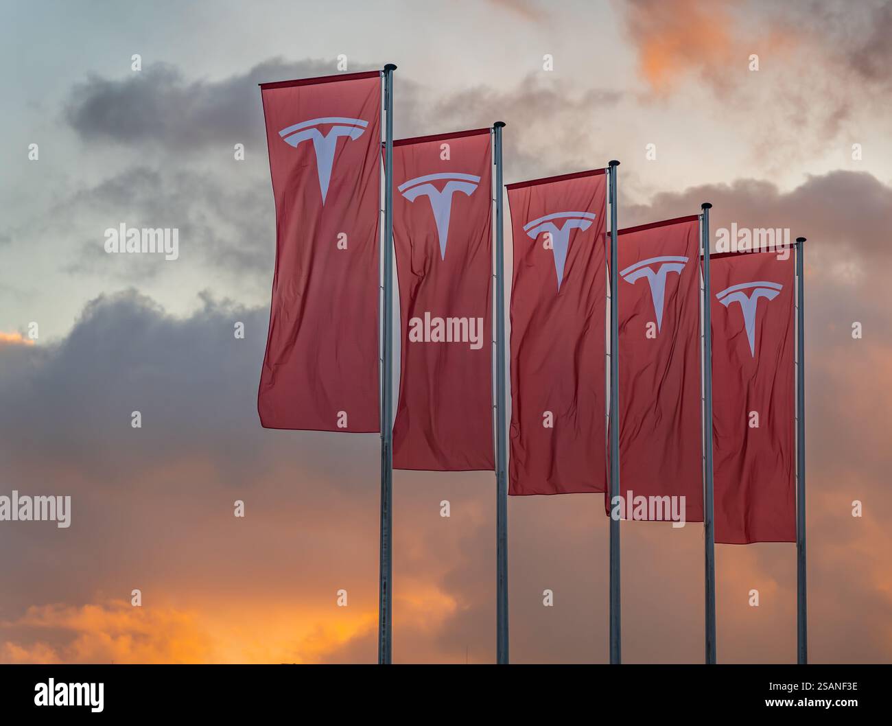 Amsterdam, Niederlande, 30.01.2025, Flaggen mit dem Logo des amerikanischen multinationalen Automobilgiganten Tesla Inc Winkt Gegen Den Sonnenuntergang Stockfoto