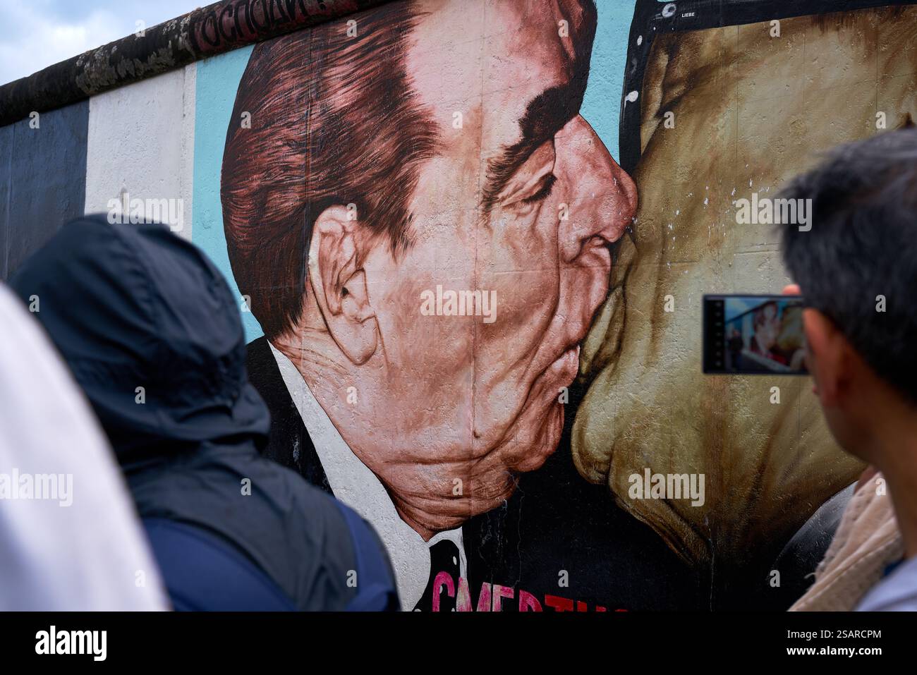 Berlin, Deutschland – 28. September 2024 – East Side Gallery Berliner Mauer Der Kuss. Touristen sehen „der Kuss“ von Dmitry Vrubel ein Wandgemälde. Stockfoto