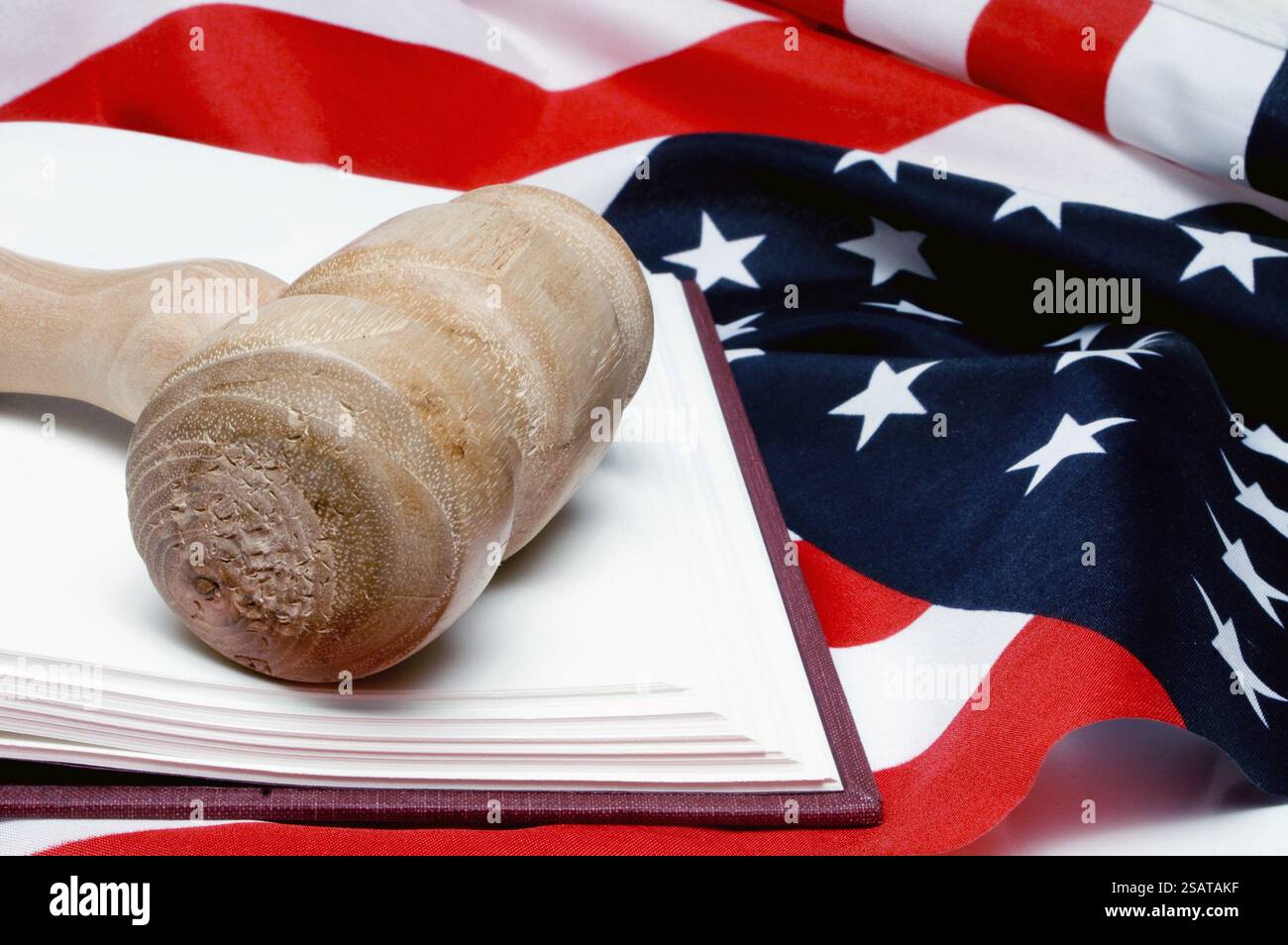 Ein offenes Gesetzbuch und ein Richter beschimpfen eine amerikanische Flagge Stockfoto