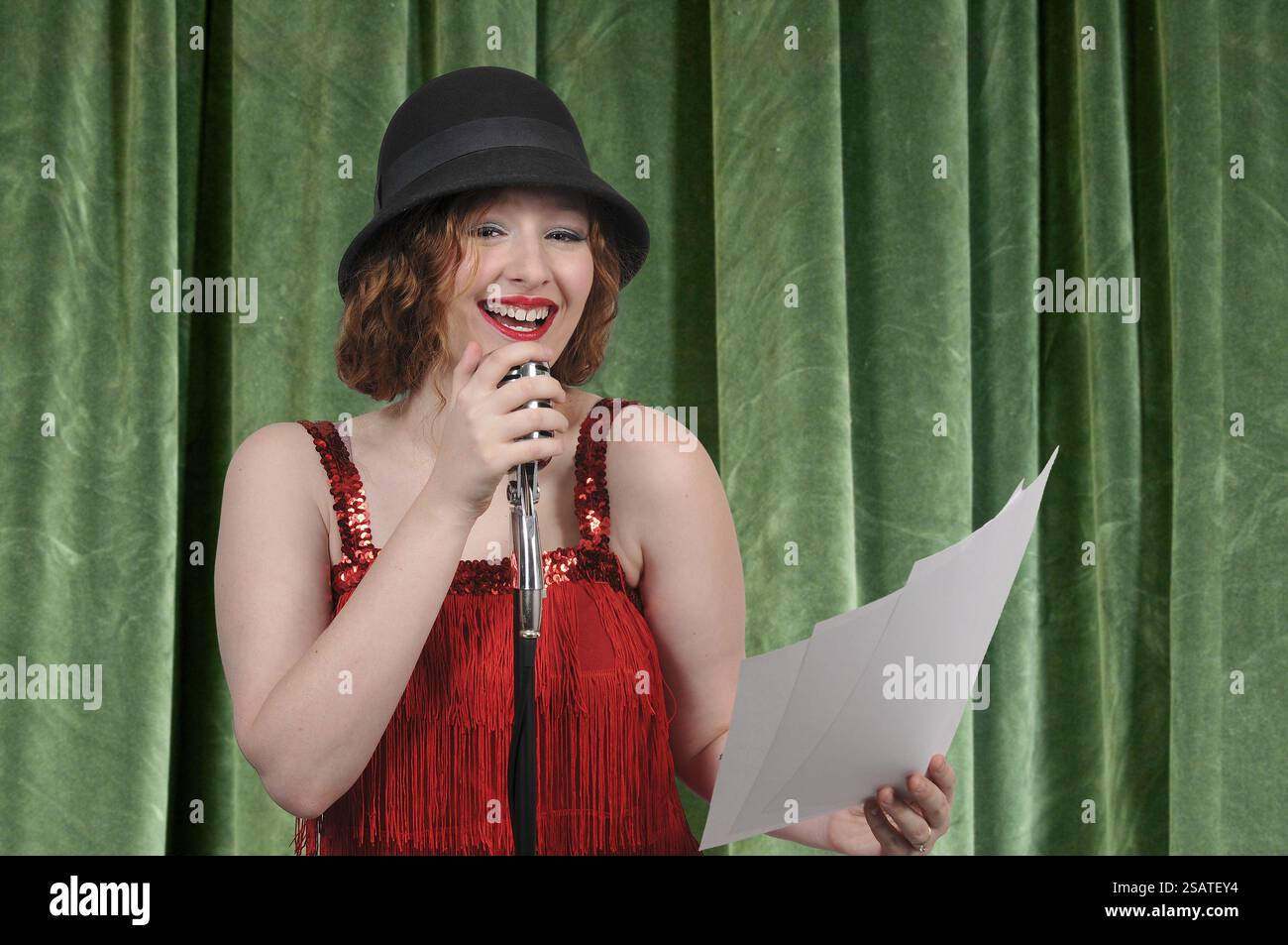 Frau in ein Vintage Mikrofon durchführen ein Hörspiel sprechen Stockfoto